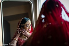 Indian bride putting earrings on Indian bride putting earrings on