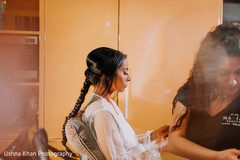 Indian bride being assisted by makeup artist Indian bride being assisted by makeup artist