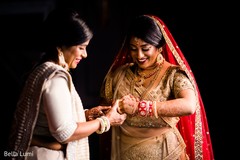 Indian bride being helped with jewelry Indian bride being helped with jewelry