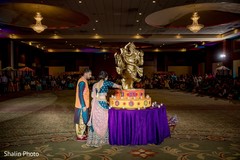 Lovely Indian couple lighting the candles on Ganesha Puja altar. Lovely Indian couple lighting the candles on Ganesha Puja altar.