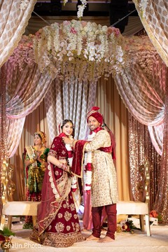 Indian groom putting flower garland to bride Indian groom putting flower garland to bride