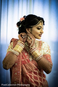 Indian bride putting earrings on Indian bride putting earrings on