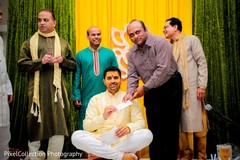 Indian wedding ritual of painting the groom with yellow turmeric paste Indian wedding ritual of painting the groom with yellow turmeric paste
