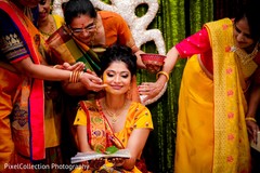 Indian wedding ritual of painting the bride with yellow turmeric paste Indian wedding ritual of painting the bride with yellow turmeric paste