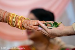 Indian couple holding the ritual leaf with rose petal and nut. Indian couple holding the ritual leaf with rose petal and nut.