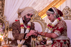 Indian groom putting wedding ring on bride Indian groom putting wedding ring on bride