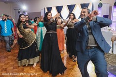 Cheerful indian bride dancing with guest Cheerful indian bride dancing with guest