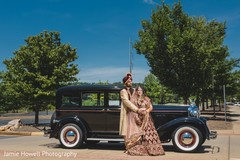Indian couple posing in front of their beautiful transportation Indian couple posing in front of their beautiful transportation