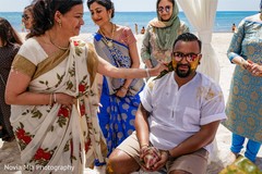 Indian groom getting turmeric paste on his face. Indian groom getting turmeric paste on his face.