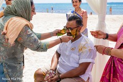 Indian relatives putting turmeric paste on Indian grooms face. Indian relatives putting turmeric paste on Indian grooms face.