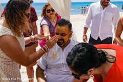 Haldi ritual where groom gets turmeric paste on face. Haldi ritual where groom gets turmeric paste on face.