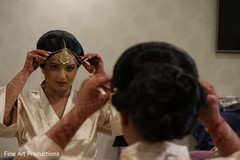 Indian bride putting the tikka on. Indian bride putting the tikka on.
