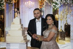 Gorgeous Indian newlyweds about to cut the cake. Gorgeous Indian newlyweds about to cut the cake.