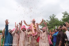 Indian groom being lifted by peach sherwani wearing groomsmen. Indian groom being lifted by peach sherwani wearing groomsmen.