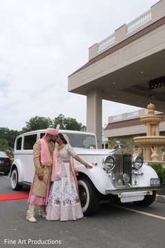 Indian newlyweds posing for pictures by their ride. Indian newlyweds posing for pictures by their ride.
