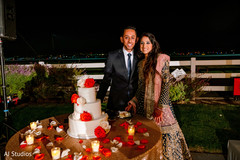 Indian bride and groom posing with cake Indian bride and groom posing with cake
