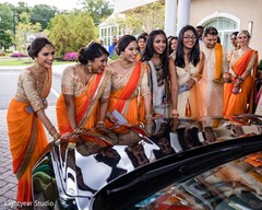 Bridesmaids wearing orange sherbet sarees after the Indian wedding. Bridesmaids wearing orange sherbet sarees after the Indian wedding.