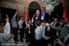 Indian groom lifted at reception party by groomsmen. Indian groom lifted at reception party by groomsmen.
