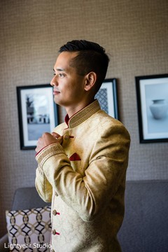 Indian groom putting on his golden sherwani. Indian groom putting on his golden sherwani.