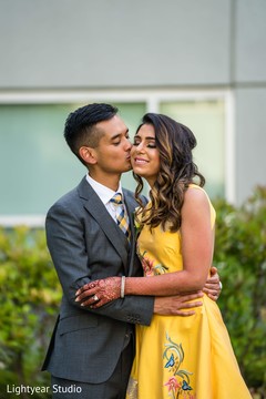 Indian groom in grey suit kissing his Maharani in yellow dress. Indian groom in grey suit kissing his Maharani in yellow dress.