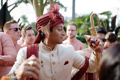 Indian groom holding his red golden coconut and golden sword. Indian groom holding his red golden coconut and golden sword.