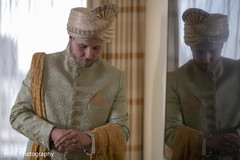 Charming Indian groom putting on his watch. Charming Indian groom putting on his watch.