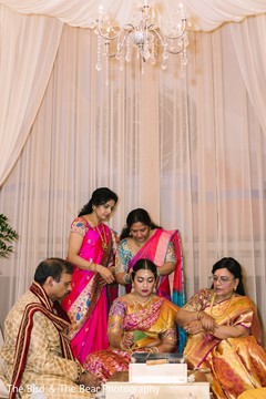Indian bride being assisted by family guests during the rituals. Indian bride being assisted by family guests during the rituals.