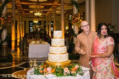 Indian bride and groom during the reception by the cake. Indian bride and groom during the reception by the cake.