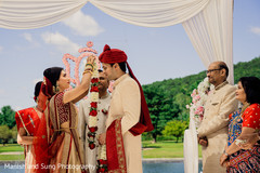 Indian bride putting white and red garland to groom. Indian bride putting white and red garland to groom.
