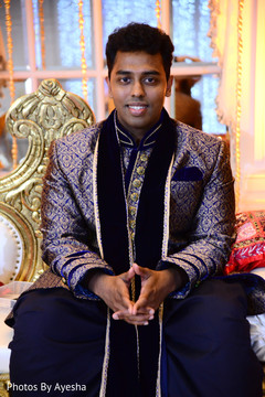 Indian groom with a blue sherwani with silver details. Indian groom with a blue sherwani with silver details.