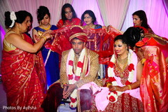 Indian bridesmaids covering Indian couple. Indian bridesmaids covering Indian couple.