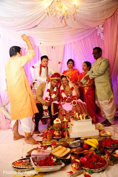 Rose petals are being tossed to the Indian couple. Rose petals are being tossed to the Indian couple.