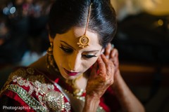 Indian bride getting her earrings on. Indian bride getting her earrings on.