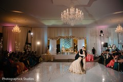 Indian couple dancing at white with lights reception stage. Indian couple dancing at white with lights reception stage.