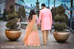 Indian bride and groom walking outdoors on their engagement outfits. Indian bride and groom walking outdoors on their engagement outfits.