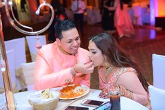 Indian groom sharing Indian food with bride at engagement dinner. Indian groom sharing Indian food with bride at engagement dinner.