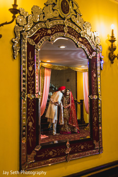 Indian couple in Hindu wedding attires reflection on a mirror. Indian couple in Hindu wedding attires reflection on a mirror.