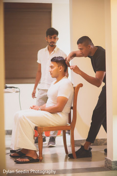 Indian groom being assisted by barber prior to the gala. Indian groom being assisted by barber prior to the gala.
