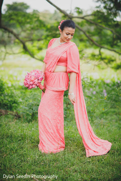 Indian bride wearing the pink bridal saree during pictures. Indian bride wearing the pink bridal saree during pictures.