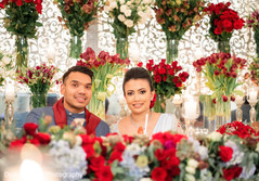 Indian couple looking at the camera surrounded by flowers. Indian couple looking at the camera surrounded by flowers.