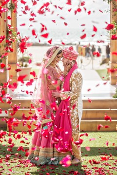 Indian couple posing on their pink and golden ceremony outfits. Indian couple posing on their pink and golden ceremony outfits.