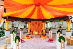 Yellow and orange drapes with floral decorations for the wedding. Yellow and orange drapes with floral decorations for the wedding.