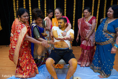 Indian groom being covered in tumeric paste. Indian groom being covered in tumeric paste.