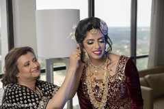 Indian bride being helped to put her jewelry on. Indian bride being helped to put her jewelry on.