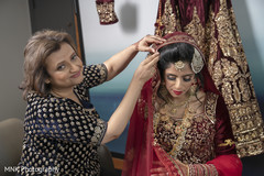Indian bride getting help to put her wedding veil on. Indian bride getting help to put her wedding veil on.