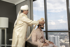 Indian groom being help to put his turban on. Indian groom being help to put his turban on.