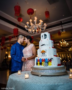 Indian couple posing next to wedding cake. Indian couple posing next to wedding cake.