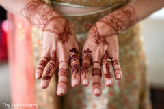 Indian bride showing her brown mehndi art and wedding rings. Indian bride showing her brown mehndi art and wedding rings.