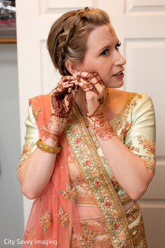 Indian bride putting on her kundan earrings. Indian bride putting on her kundan earrings.