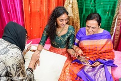 Indian bride with relative looking at her brown henna art. Indian bride with relative looking at her brown henna art.
